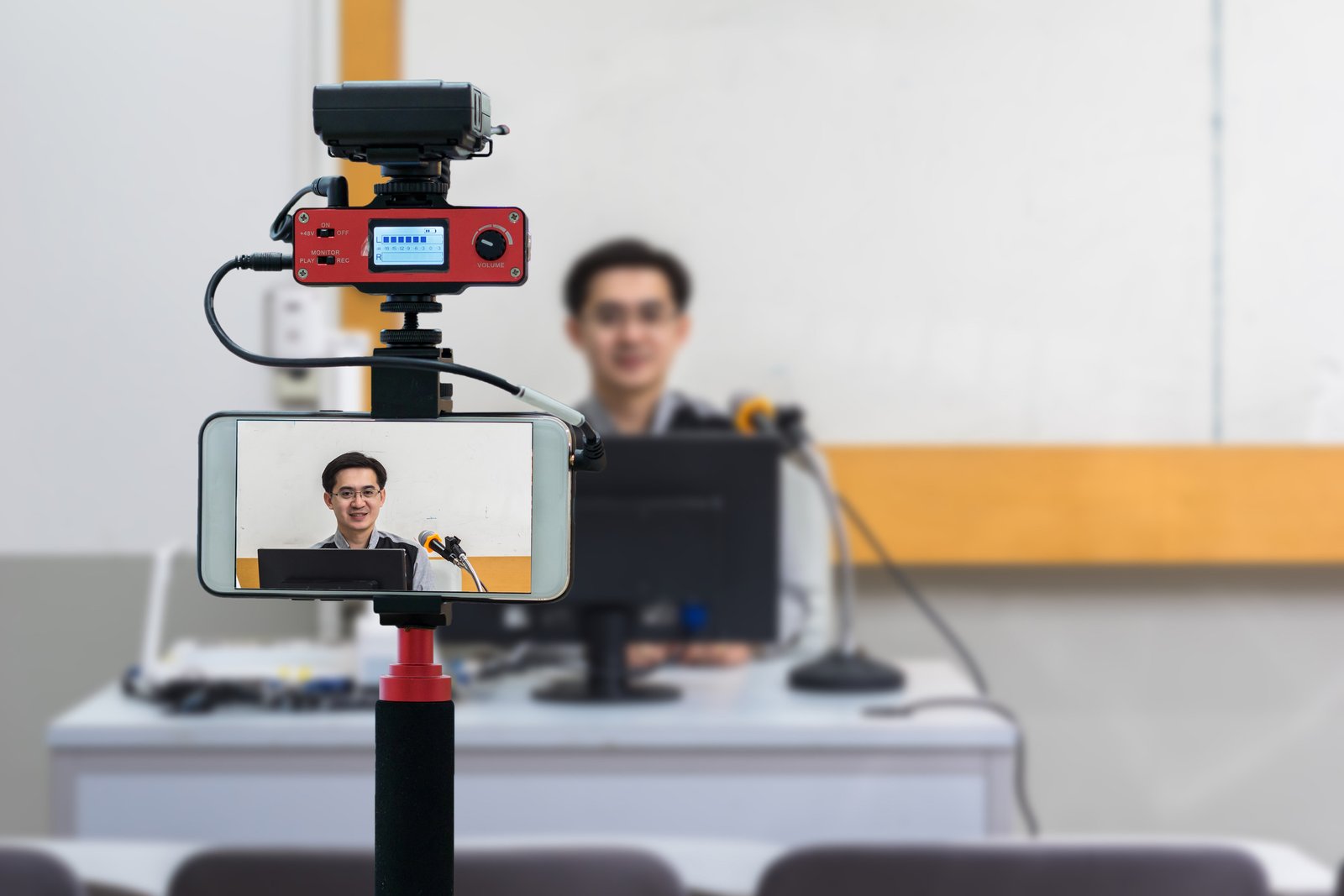 Closeup smart mobile phone taking Live of Asian teacher in the c